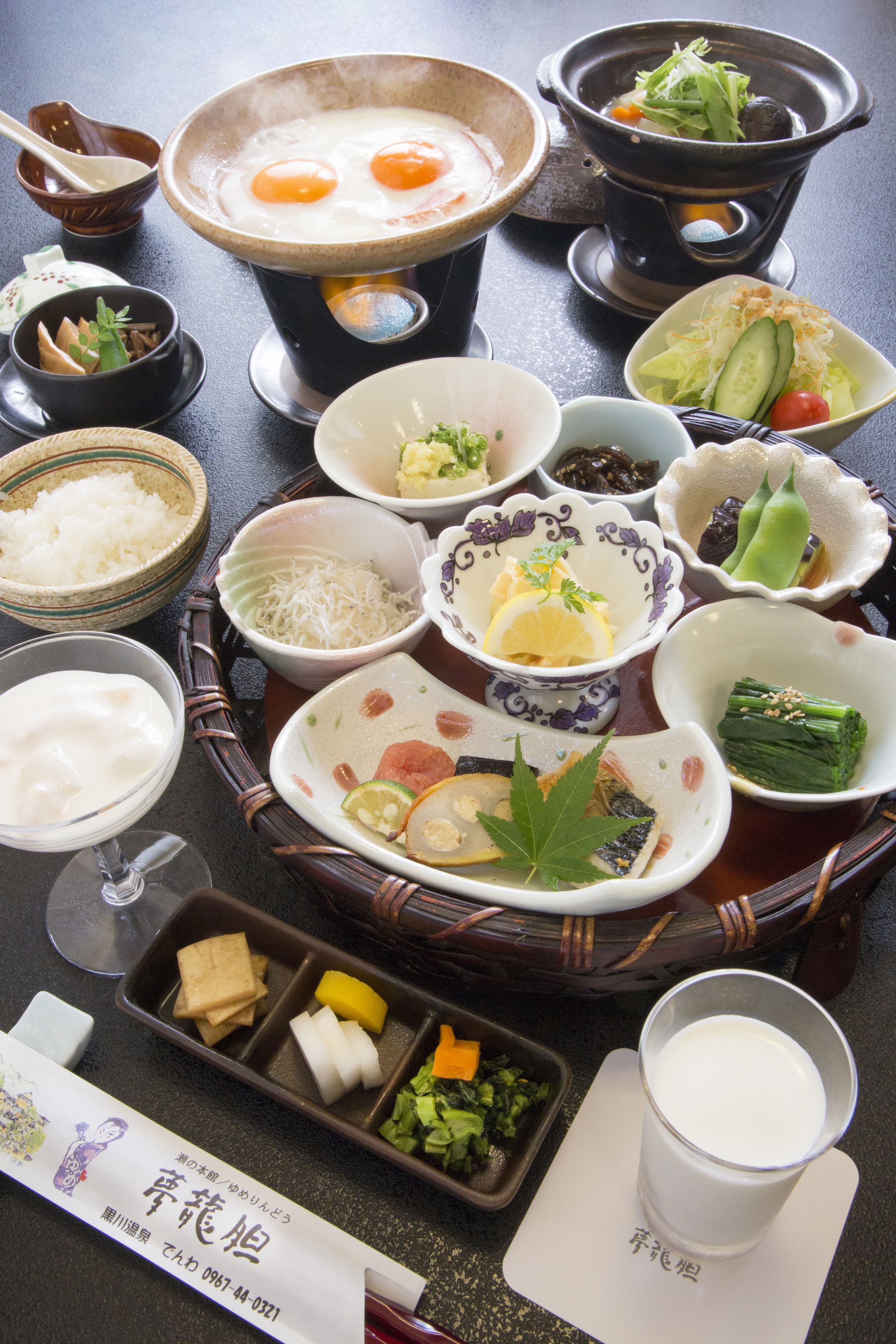 Variedad de platos japoneses, incluyendo un hot pot, arroz y varios acompañamientos.