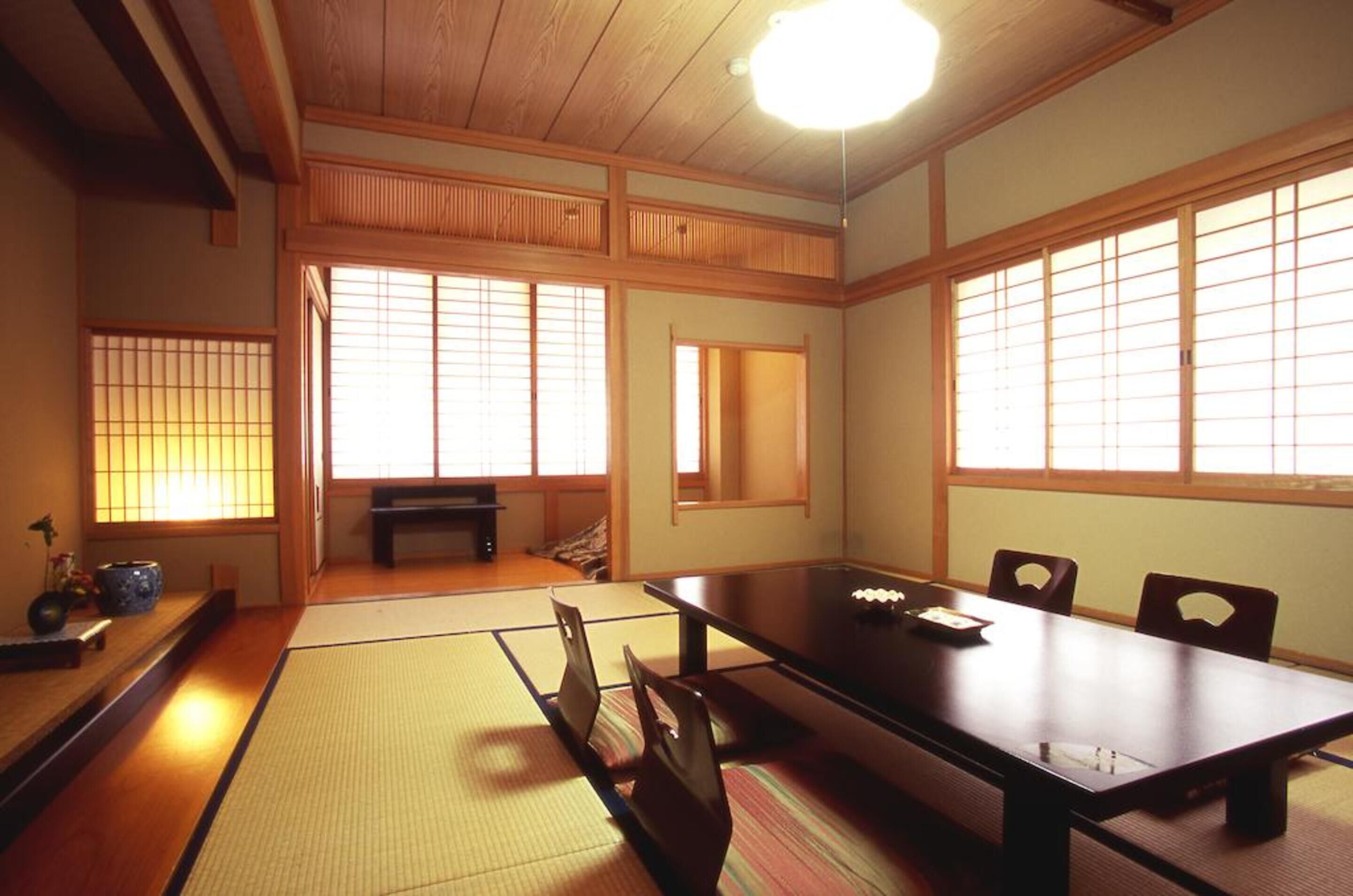 A traditional Japanese room with tatami flooring, a low table, and sliding doors.