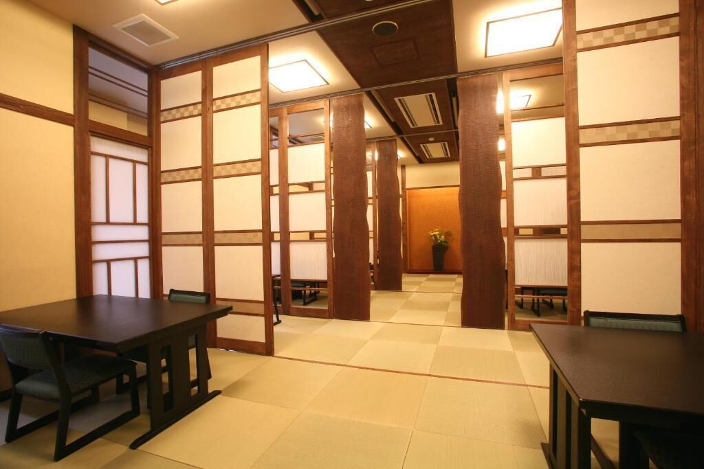 Una habitación de estilo japonés tradicional con suelo de tatami, puertas correderas y una mesa de madera baja.