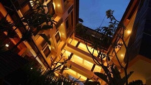 A multi-story building with illuminated balconies and a garden area. - Bali World Hotel (Bandung)