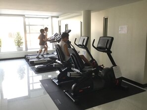 A gym with treadmills and a person walking on a treadmill. - The Lake 3 Condominium (Pak Kret)