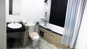 A bathroom with a sink, toilet, and bathtub. - The Icon Service Apartment (Si Maha Phot)