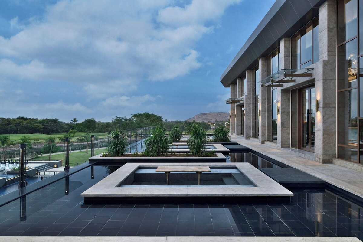 Un hôtel moderne doté d’une piscine sur le toit, avec un long couloir aménagé de sièges et offrant une vue sur le paysage environnant.