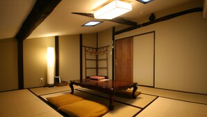 Une pièce de style japonais traditionnel, avec un sol recouvert de tatamis, une petite table en bois et une porte coulissante.