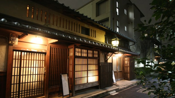 Un bâtiment traditionnel japonais doté de portes coulissantes en bois et d'une enseigne.