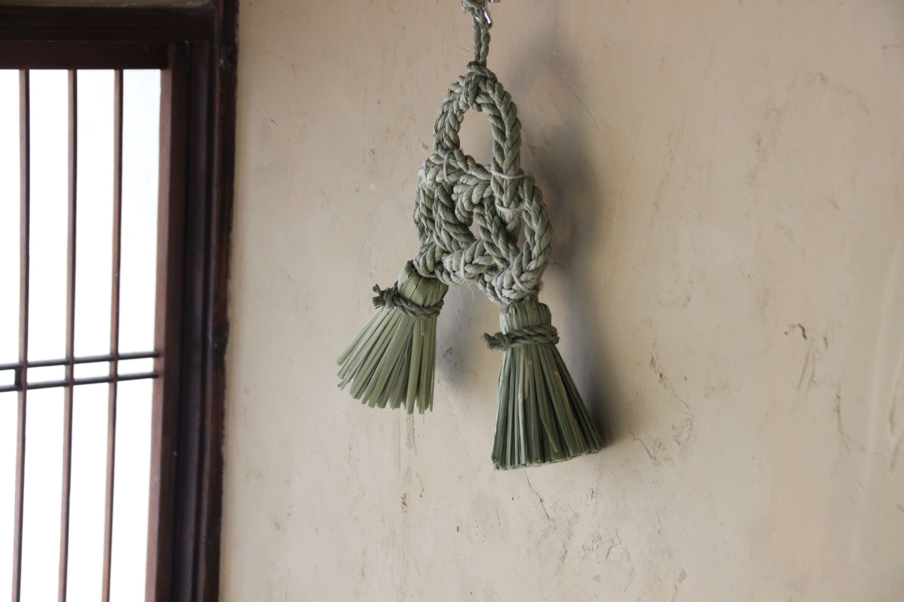 Une décoration murale en macramé réalisée avec de la corde et ornée de franges.
