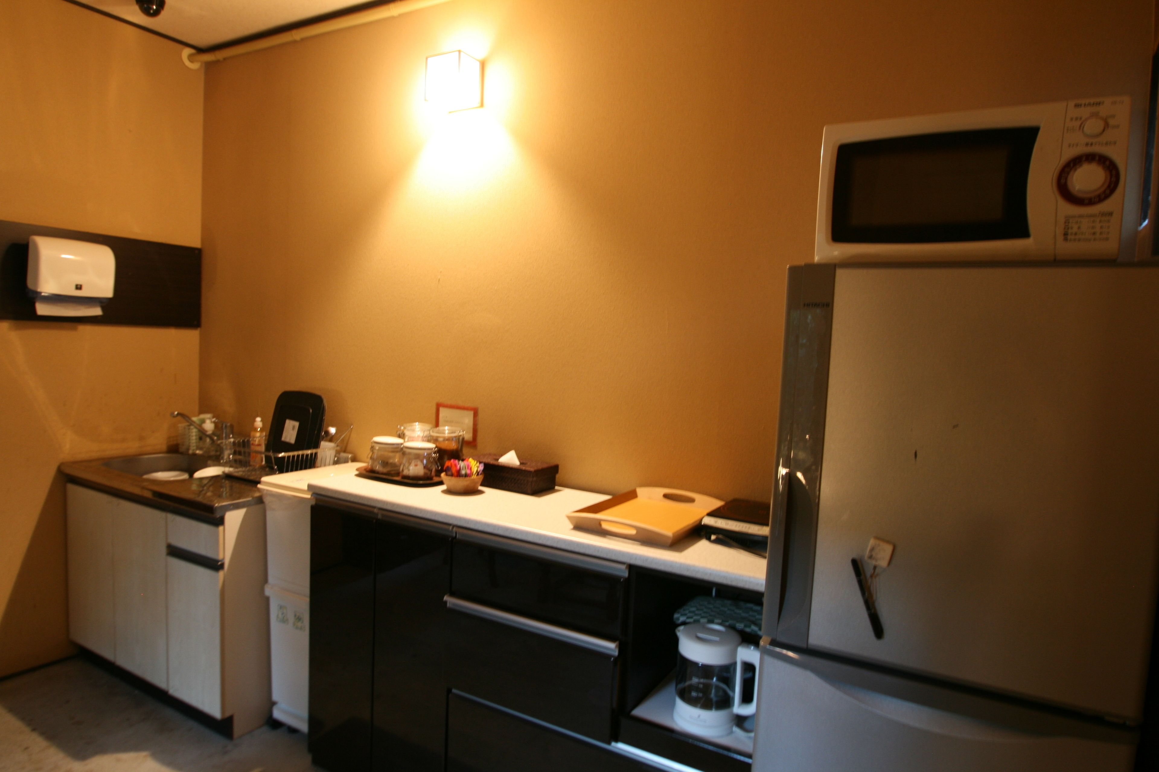 A compact kitchen with a microwave, coffee maker, and a small refrigerator.