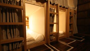 Una habitación con literas, estantes de madera y suelo estampado.