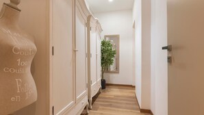 A hallway with a large mannequin, a potted plant, and a mirror on the wall. - Flaminia Rooms&Suites (Rome)