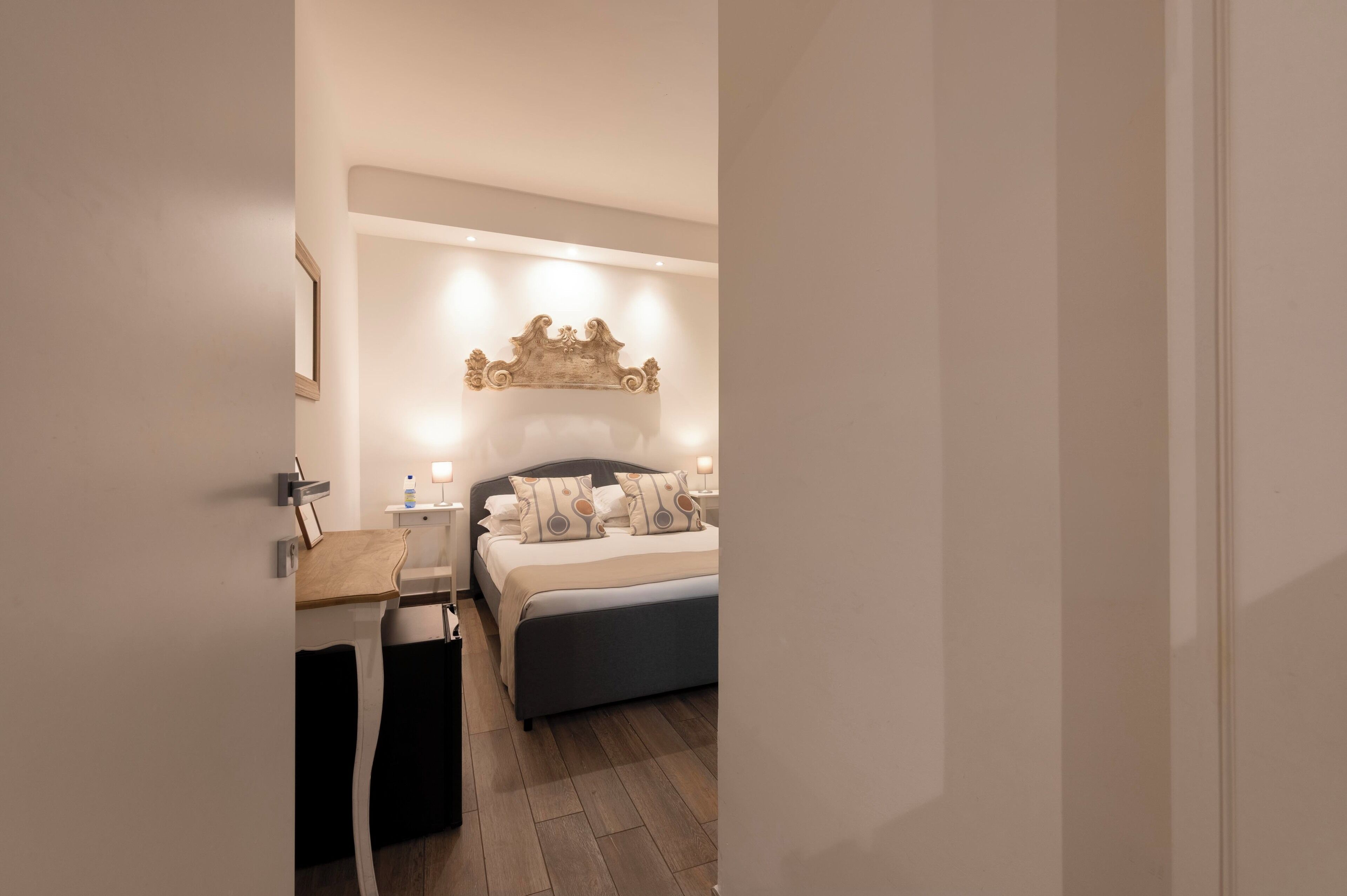 Un dormitorio moderno con cama, mesitas de noche y un adorno en la pared.