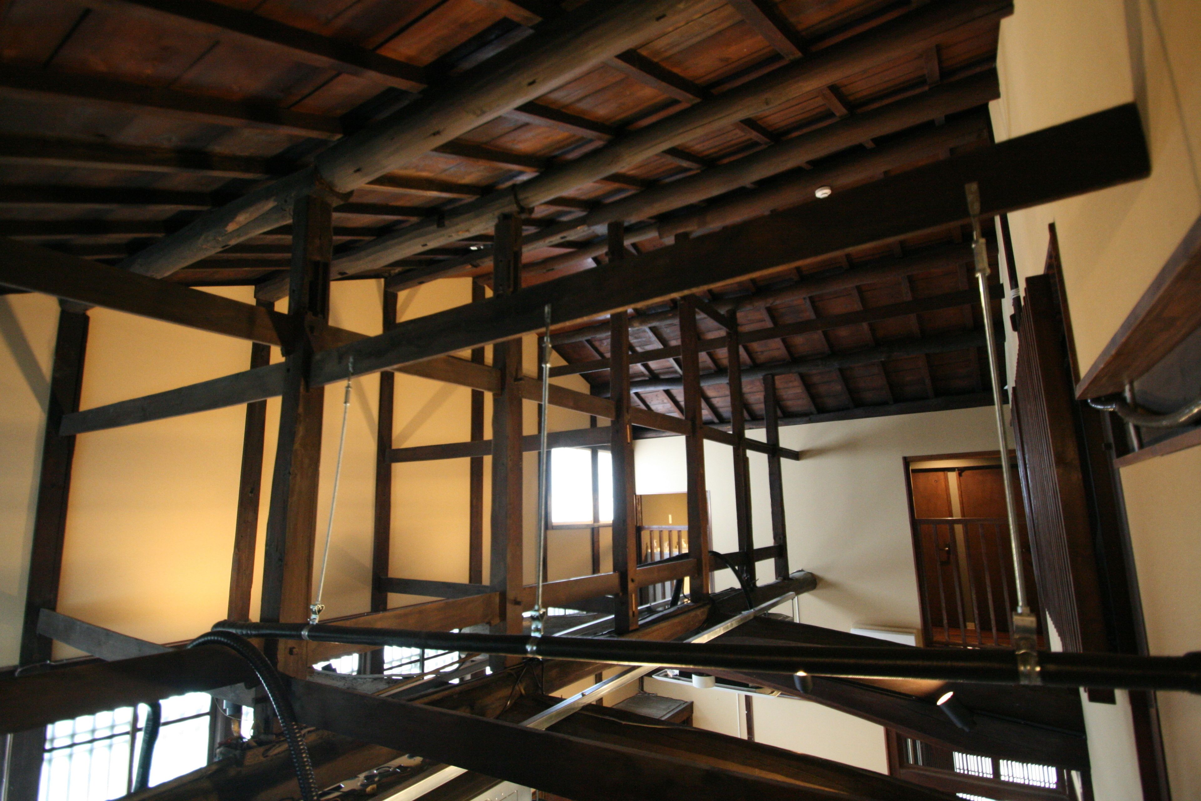 Un interior de madera con vigas a la vista y una escalera.