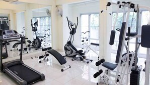 A gym with treadmills, elliptical machines, and weight stations. - Jitthamas Residence (Bangkok)