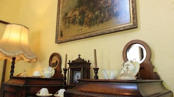 Un aparador de madera antiguo con espejo, un reloj y una lámpara.