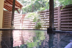Um deck de madeira com piscina, cercado por uma vedação de madeira e árvores.