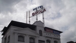 Un edificio con un cartel en el techo que dice "HOTEL BHOLLA".
