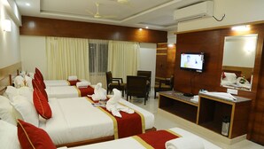 Une chambre d’hôtel avec deux lits, une télévision, un bureau et un miroir.
