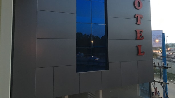 A hotel building with a large window and the word "HOTEL" displayed vertically on the facade. - Housefinch Residency (Bengaluru)