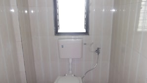 Un baño pequeño y limpio con inodoro, lavabo y ventana.
