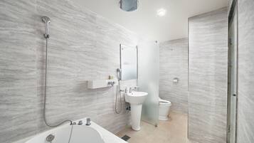 A modern bathroom with a freestanding bathtub, a pedestal sink, and a glass-enclosed shower.
