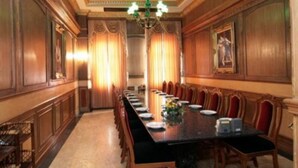 A formal dining room with a long table, red upholstered chairs, and a chandelier. - 13 Coins Ngamwongwan Hotel (Nonthaburi)