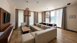 Una sala de estar moderna con sofá, mesa de centro, televisor y comedor.