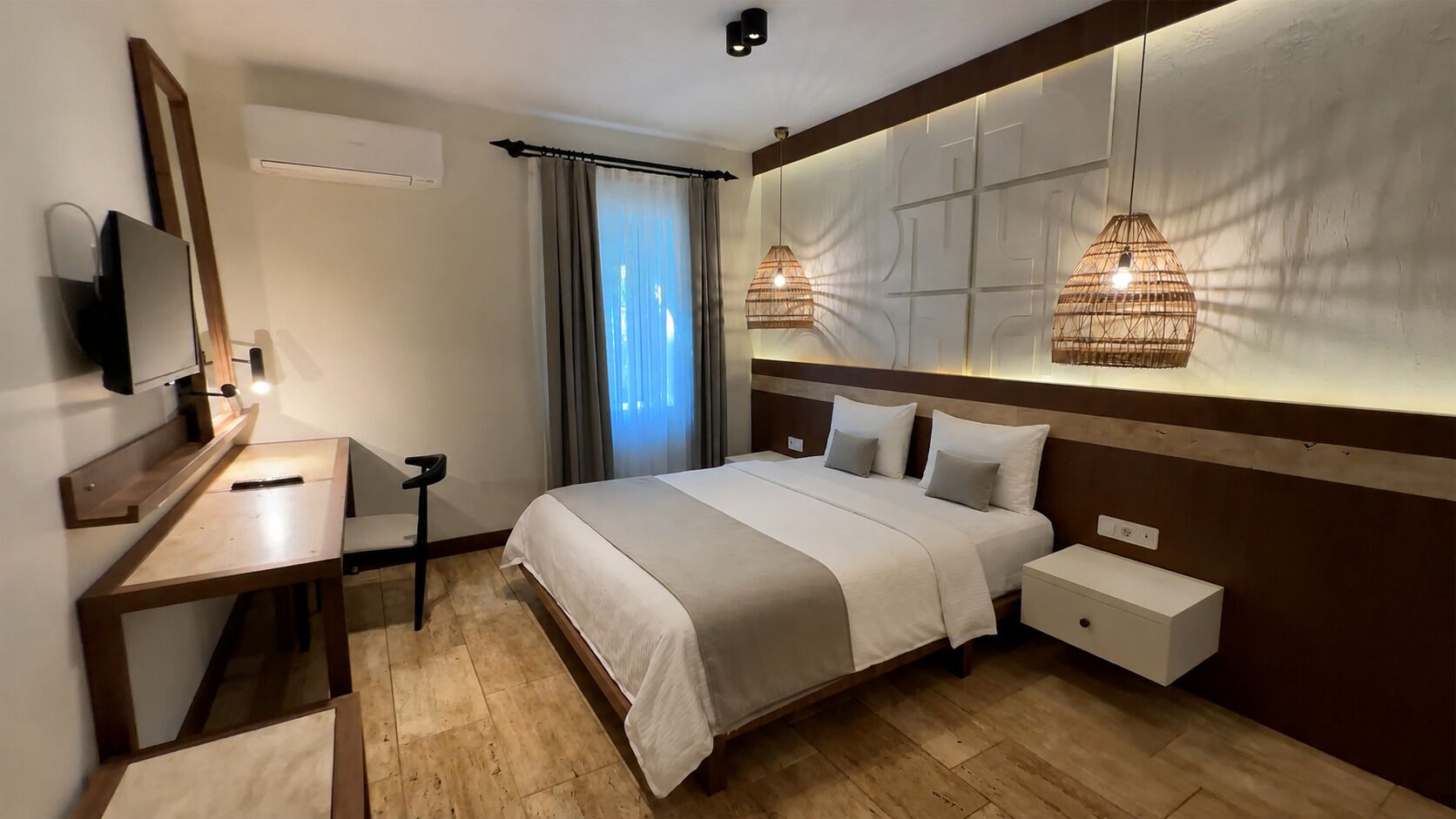 Une chambre d’hôtel équipée d’un lit, d’une table de chevet, d’une télévision et d’un bureau avec une chaise.
