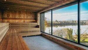 A wooden interior with a large window overlooking a lake. - Best Western Plus Le Roi Arthur Hotel et Spa (Ploërmel)