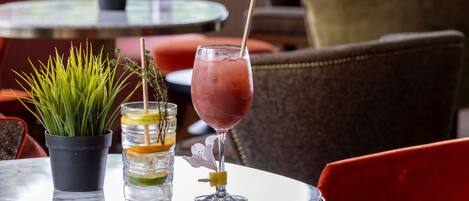 A table with a drink, a potted plant, and a glass with a straw.