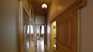 Un couloir avec des portes en bois et un luminaire au plafond.