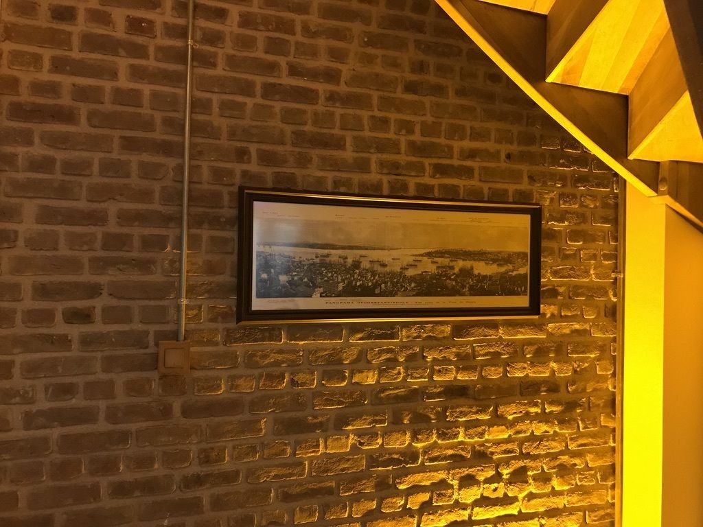 Un mur de briques avec un tableau encadré.