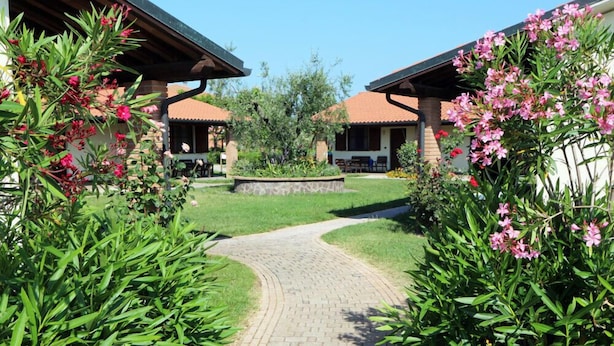 A pathway leading to a building with a brick facade and a tiled roof.