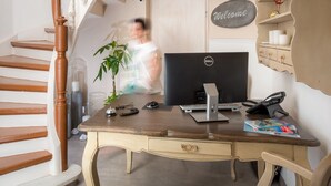 A home office with a desk, computer, and a staircase.