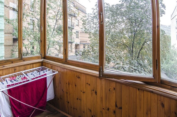 A room with wooden paneled walls and large windows overlooking a tree-lined street. - Rent Kiev Vladimirskaya (Kyiv)