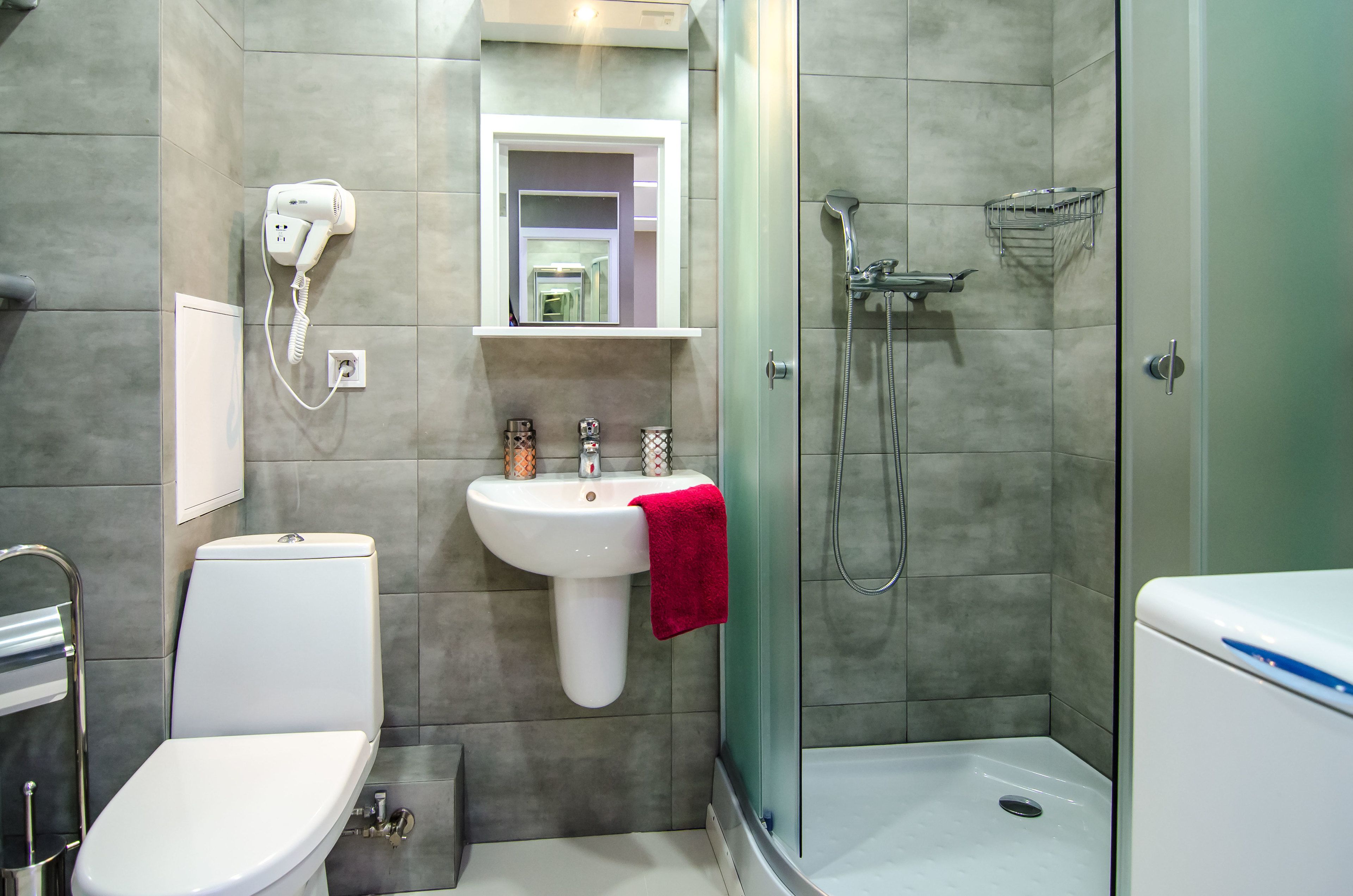 A modern bathroom with a toilet, sink, and shower.