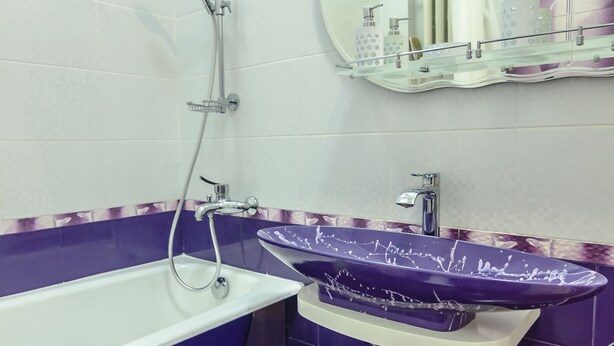 A bathroom with a bathtub, a sink with a purple basin, and a mirror above the sink. - Rent Kiev Maidan Nezalezhnosti (Kyiv)