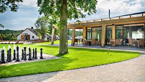A chessboard set on a paved area with a building in the background. - Rezydencja nad jeziorem - Pestkownica (Krzyz Wielkopolski)
