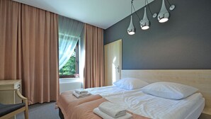 A hotel room with a large bed, two pillows, a bedside table, and a chair. - Rezydencja nad jeziorem - Pestkownica (Krzyz Wielkopolski)