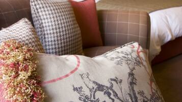 A hotel room with a bed, multiple pillows, and two bedside lamps.