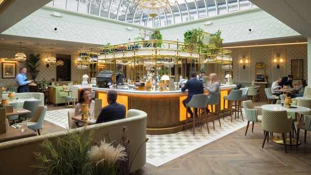 A spacious hotel lobby with a high ceiling, a central bar area, and seating arrangements. - Marcliffe (Aberdeen)