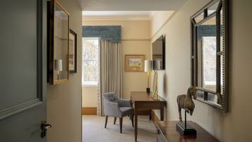A hotel room with a desk, chair, and a large mirror.