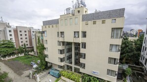Un edificio de varios pisos con techo plano y varios balcones, con un letrero que indica que es un complejo residencial.