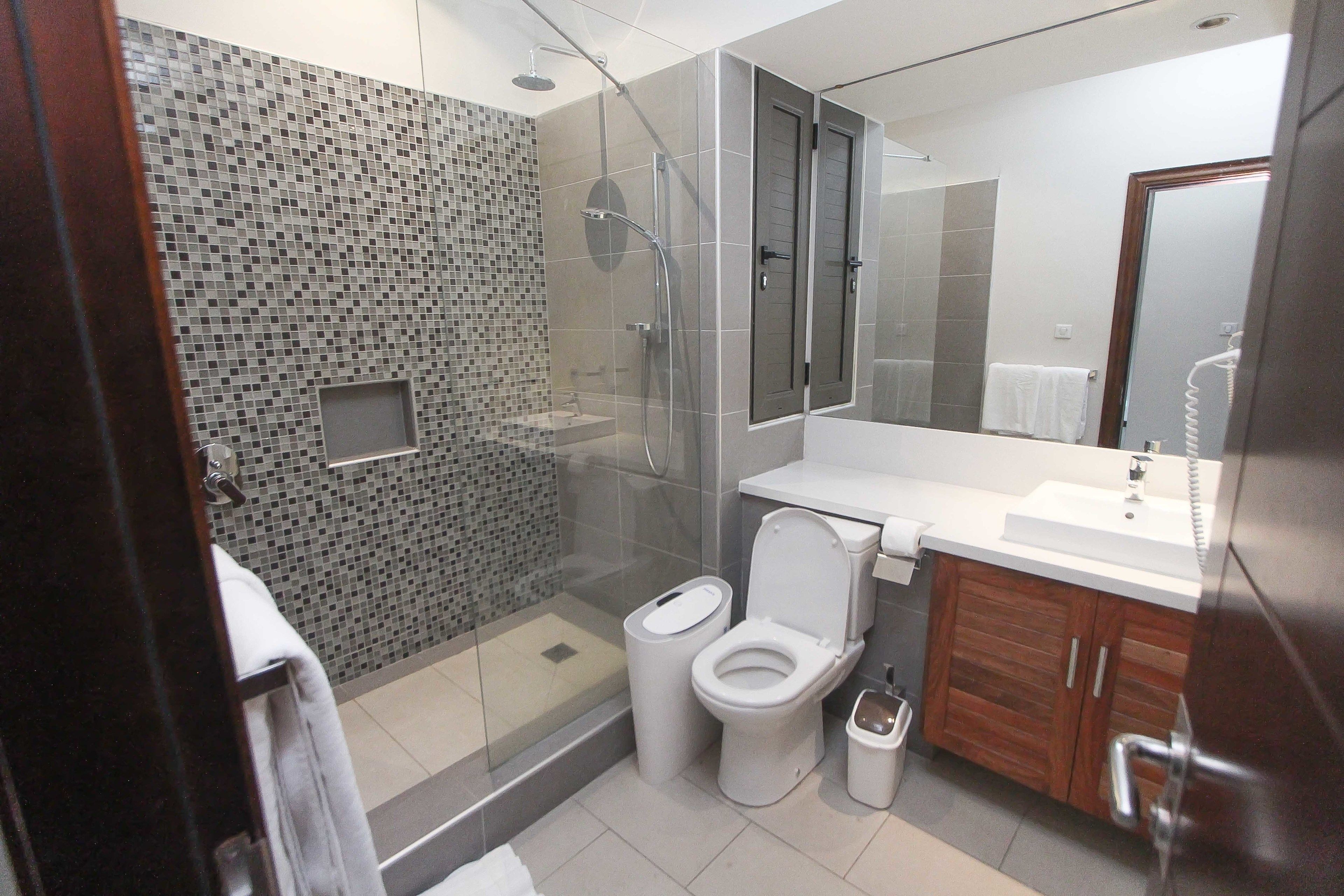 Un bagno moderno con doccia vetrata, servizi igienici e lavandino.