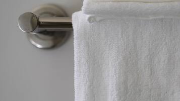 Une serviette blanche est suspendue à une barre à serviettes en métal.