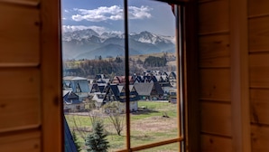A window view of a mountain landscape with houses. - Domki z Widokiem (Zakopane)