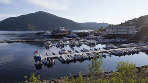 En lysthavn med fortøjede både, en anløbsbro og bygninger i baggrunden.