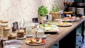 Una mesa de buffet con diversos alimentos, como ensaladas, frutas y productos lácteos.