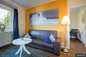 Suite, niet-roken, balkon | Woonkamer | Een 32-inch flatscreentelevisie met kabelzenders en een televisie