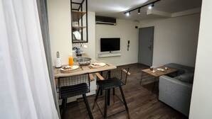 A compact living space with a kitchenette, dining area, and a gray sofa. - Arkem Maltepe (Istanbul)