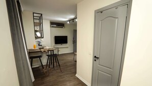 A compact kitchen with a dining area, a flat-screen TV, and a door leading to another room. - Arkem Maltepe (Istanbul)