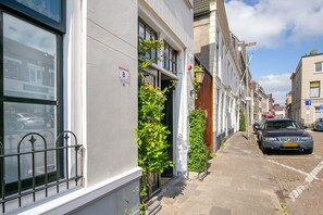 A narrow street with terraced houses, a parked car, and a visible 'B' parking sign. - Tourist Travel Inn (Schiedam)